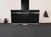 A modern black kitchen range hood mounted on a white wall above a dark gray cabinet. Produktbild-Vorschau