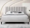 A bed with a padded headboard and bedding in a room. Produktbild-Vorschau