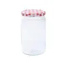 A clear glass jar with a red and white checkered lid, isolated on a white background. Produktbild-Vorschau