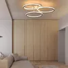 A modern living room with a sofa, wooden wardrobe, and a contemporary ceiling light. Podgląd zdjęcia produktu