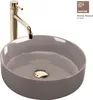 A close-up studio shot of a round beige vessel sink with a gold drain and a gold faucet. Náhľad obrázku produktu