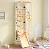A children's indoor climbing frame with a slide and swing, set up in a room with a painted bear on the wall. Voir les images du produit