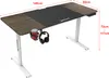 A computer desk with adjustable height, featuring a dark wood finish, black desk mat, and accessories like a cup holder and headphones. Náhled obrázku produktu