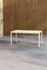 A rectangular table with beige top and legs is placed on a concrete floor in front of a wooden slatted wall. Podgląd zdjęcia produktu