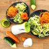 A spiralizer and spiralized vegetables are arranged on a wooden surface. Náhled obrázku produktu