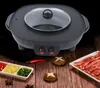 A multi-functional electric hot pot and grill is displayed on a wooden surface, surrounded by ingredients like sliced meat, chili peppers, ginger, and scallions. Voir les images du produit