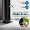 A black solar shower with a chrome faucet, shown on a concrete and wooden deck with grass in the background. Text overlays describe features. Produktbild-Vorschau