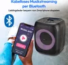 A person holding a smartphone displaying a music app next to a portable Bluetooth speaker with purple lighting. Produktbild-Vorschau