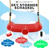 A red swing seat suspended by ropes against a blue sky with clouds and marketing text. Produktbild-Vorschau