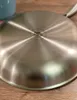 The bottom of a stainless steel frying pan is shown on a wooden surface. Produktbild-Vorschau
