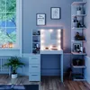 A well-lit vanity table with a mirror and LED lights, surrounded by shelves and decorative items, in a room with a window. Anteprima dell’immagine prodotto