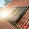 Two VELUX skylights with sunshades installed on a tiled roof, with bright sunlight shining. Voir les images du produit