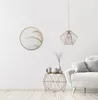 A modern living room with a round gold mirror on a white wall, a geometric side table with decorative items, and a white sofa. Náhled obrázku produktu