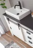 A bathroom vanity with a sink and faucet, set in a modern bathroom. Produktbild-Vorschau