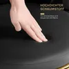A hand pressing into a black cushion, with text overlays highlighting product features. Produktbild-Vorschau