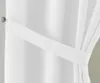 A close-up view of a white curtain held back by a white fabric tie. Produktbild-Vorschau