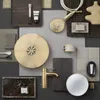 A flat lay arrangement of bathroom fixtures and accessories, including a showerhead, faucet, mirror, soap, and toiletries. Produktbild-Vorschau