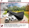 A motorcycle covered by a black protective cover, set against a background depicting different seasons (winter, spring, summer, autumn). Produktbild-Vorschau