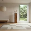 A modern living room with a wooden decorative column, a bench, and a large window overlooking a garden. Voir les images du produit