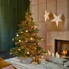 A decorated Christmas tree stands next to a fireplace, with gifts underneath. Voir les images du produit