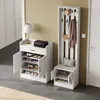 A white shoe cabinet and a white hall tree with a bench are shown in a room with a light yellow wall and gray floor. Produktbild-Vorschau
