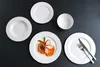 A table setting with several white plates and a bowl, with one plate featuring a meal. Produktbild-Vorschau