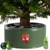 A green Christmas tree stand with a real Christmas tree trunk inserted, along with two green Christmas ornaments and a small green gift box with a ribbon. Podgląd zdjęcia produktu