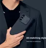 A person in a suit holding a phone case. Voir les images du produit