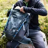 A person is packing a backpack with hiking poles attached. Anteprima dell’immagine prodotto