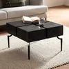 A modern living room scene with a black wooden coffee table in the foreground, a sofa in the background, and a rug underneath the table. Anteprima dell’immagine prodotto