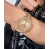 A close-up shot of a person's wrist wearing a gold Guess watch. Podgląd zdjęcia produktu