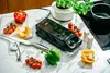 A kitchen counter with a grill, vegetables, and cooking utensils. Náhľad obrázku produktu