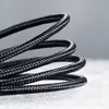 A close-up shot of a coiled black USB cable. Produktbild-Vorschau