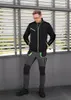 A man wearing workwear stands in front of a slatted wall. Produktbild-Vorschau