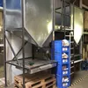 Industrial setting with large storage hoppers and a blue plastic bin. Anteprima dell’immagine prodotto