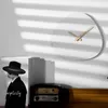 A minimalist interior scene with a clock, a child in a hat, and vintage radio. Voir les images du produit