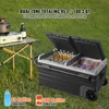 A dual-zone cooler is open and filled with drinks and food, placed on grass next to a portable table with a camping stove and a bottle. Produktbild-Vorschau