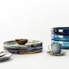 A collection of ceramic dishes and a cup and saucer, arranged on a white surface. Produktbild-Vorschau