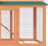 A close-up view of a wooden rabbit hutch with green roofing and wire mesh. Náhled obrázku produktu