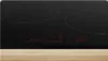 A close-up shot of a black induction cooktop with red digital displays. Voir les images du produit