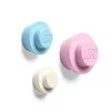 Three LEGO-inspired wall hooks in different colors (light blue, light pink, and white) are mounted on a white background. Produktbild-Vorschau
