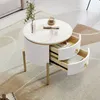 A round white coffee table with two drawers is placed on a rug in a living room. Anteprima dell’immagine prodotto