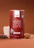 A can of hot chocolate powder is displayed prominently against a brown background, with a cup of prepared hot chocolate and chocolate pieces visible. Produktbild-Vorschau