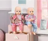 Two baby dolls sitting on a pink dresser with pink curtains in the background. Podgląd zdjęcia produktu