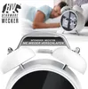 A man sleeping in bed with a white alarm clock on a nightstand. The alarm clock has a digital display showing 6:30. Text overlays highlight features of the alarm clock. Anteprima dell’immagine prodotto