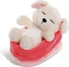 A plush toy dog sleeping in a pink and red bed. Produktbild-Vorschau