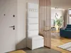A white entryway storage unit with a bench and coat hooks is shown next to a white door, with a glimpse of a living room through a wooden slat divider. Náhľad obrázku produktu