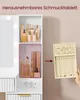 A vanity table with makeup and a jewelry organizer. The jewelry organizer is being pulled out of a compartment. Produktbild-Vorschau