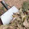 A close-up view of a flat shovel with a metal blade and black handle, digging into a pile of dry leaves and soil. Náhľad obrázku produktu