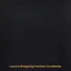 A close-up view of black faux leather material with text at the bottom. Produktbild-Vorschau